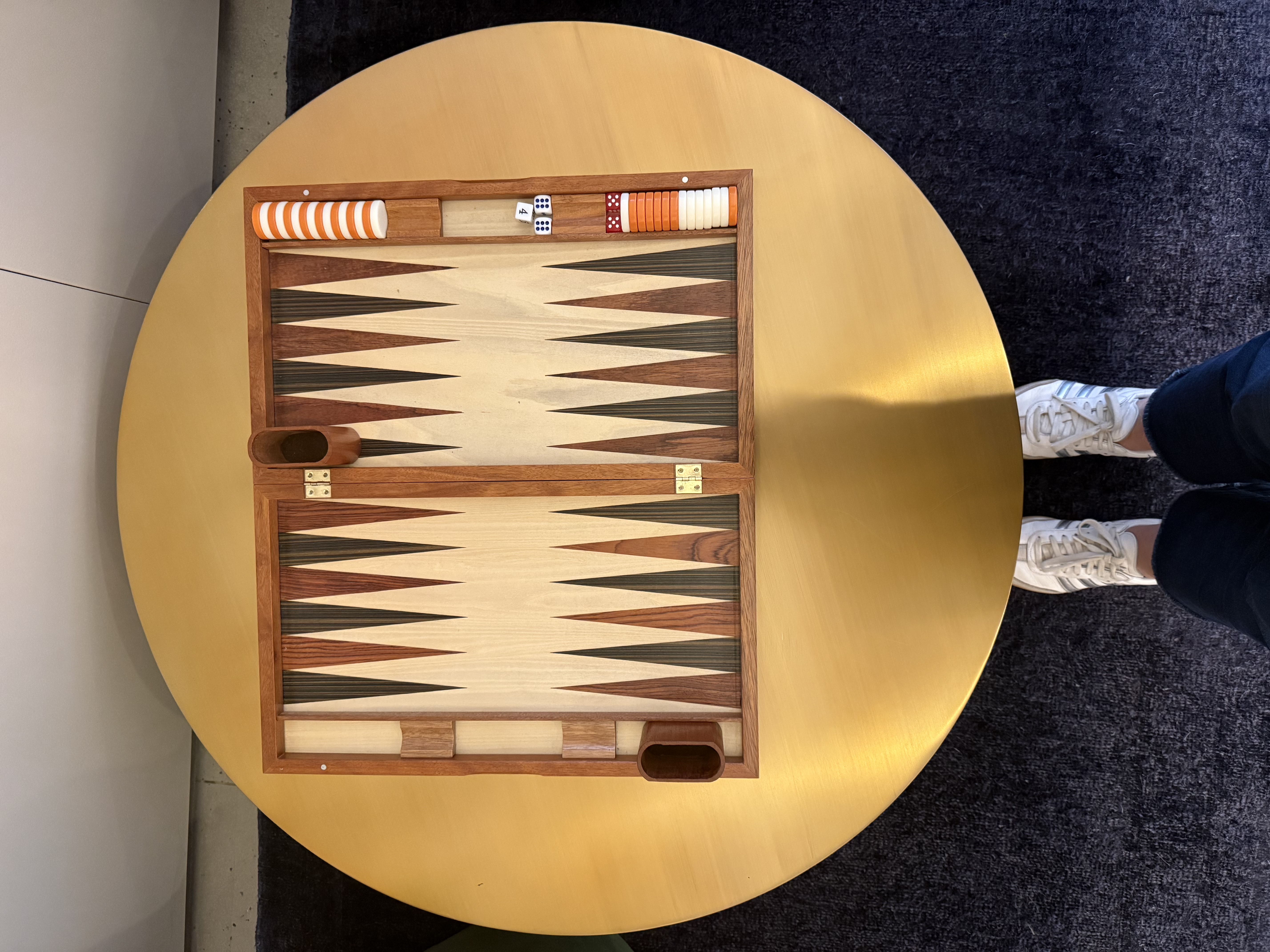 Overhead view of a backgammon board on a round table