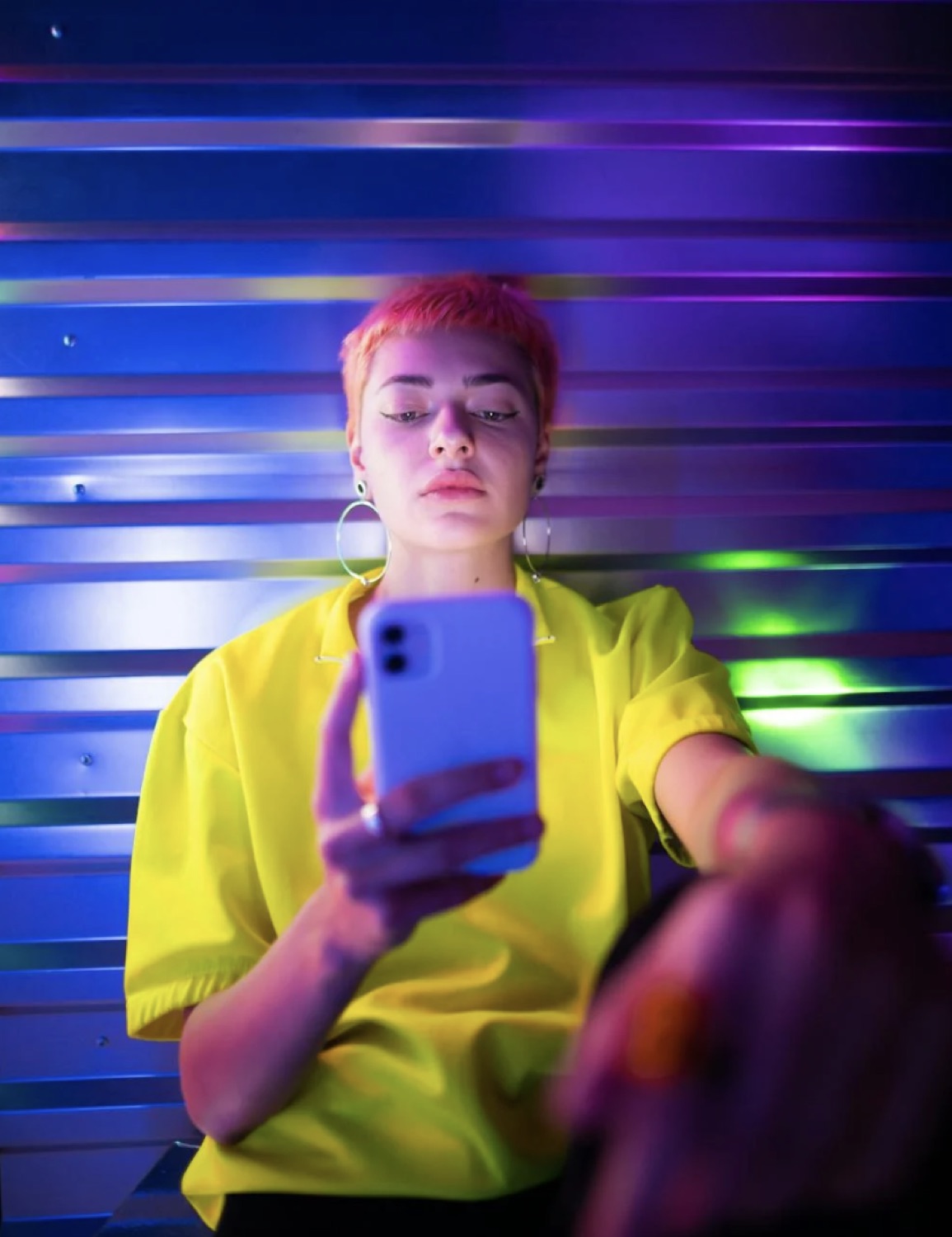 A young creator taking a selfie under vivid neon light